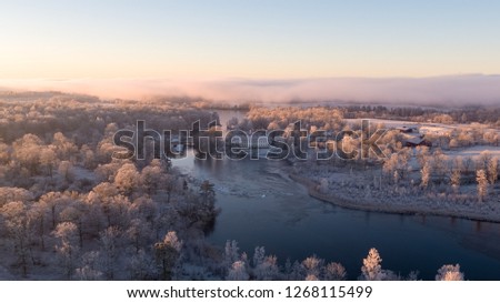 Aerial picture of a mansion by a lake on a cold winter day