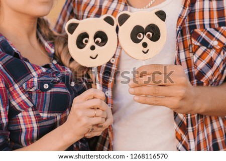 two panda candies in the hands of a guy and a girl