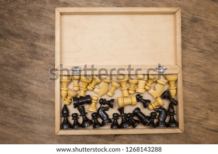 Open chess box with some black and white chess figures inside