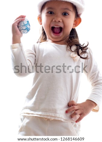 The four-year-old girl holds an Easter egg. On the white background For the Easter concept