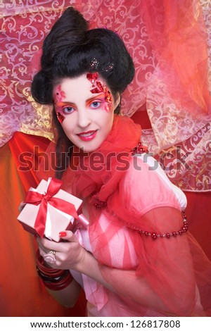 Young woman in creative image posing with present box.