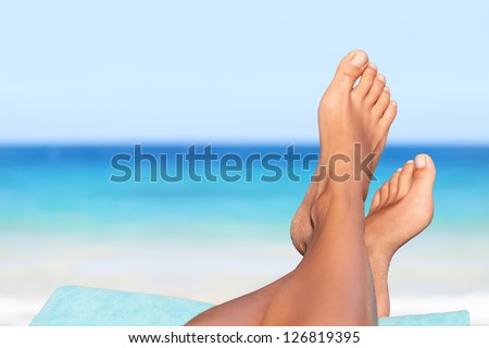 Vacation holidays. Woman feet closeup of girl relaxing on beach on sunbed enjoying sun on sunny summer day. Royalty-Free Stock Photo #126819395