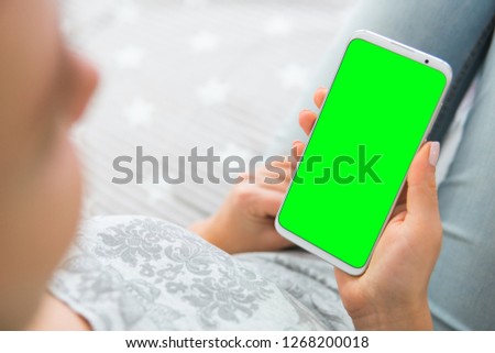 key image of womans hands Mockup chroma Green screen smartphone. holding mobile phone. close up.