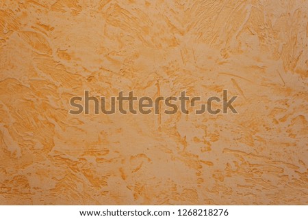 Texture of decorative plaster with a relief. Orange plaster. Abstract. Close-up.