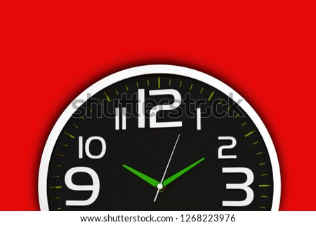 Simple round black clock with white numbers isolated on red background. 