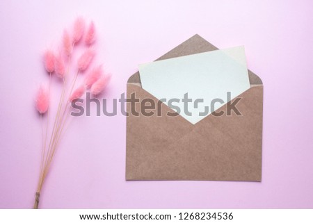Minimalistic card mockup with lagurus ovatus. pink spikes. craft envelope, blossom, flat lay, top view