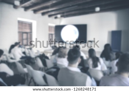blurred image of production team is sitting and standing, the chairman is talking with the business project in television studio station