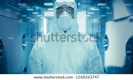 Scientist / Virologist / Factory Worker in Coverall Suit Disinfects Himself in Decontamination Shower Chamber. Biohazard Emergency Response. High Tech Research. Royalty-Free Stock Photo #1268263747