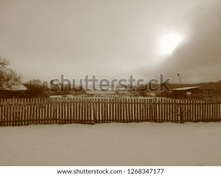 Winter landscape in the old village. Black and white photo