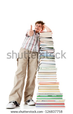 Student standing close to pile of books showing ok sign on white background