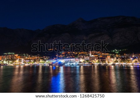 Postcard with night view of Makarska with beutiful illumination and reflections of the city, Croatia