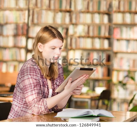 girl with tablet computer in library