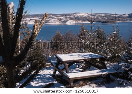 Beautiful winter photo  in the park with woden bench and blue Vlasina lake