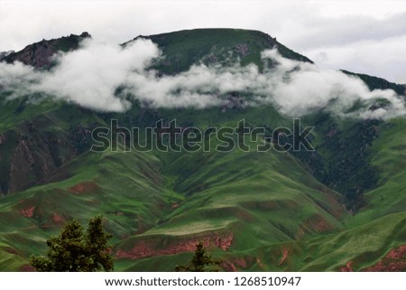 Landscape. Clouds move in between the green mountains. Created in Tibetan Plateau, China, 07/09/2018