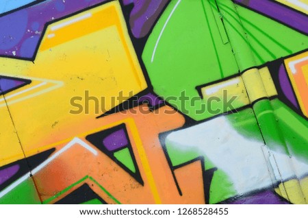 Fragment of graffiti drawings. The old wall decorated with paint stains in the style of street art culture. Multicolored background texture