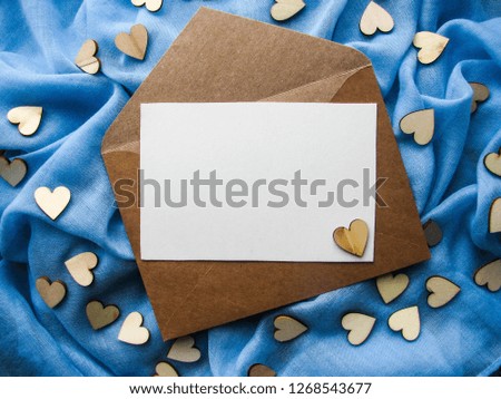 romantic concept. envelope and wooden hearts on blue background