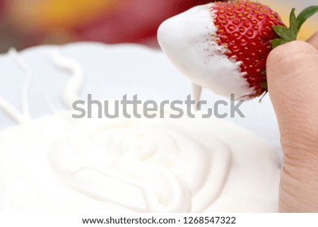 The white cream and strawberry mixing in it
