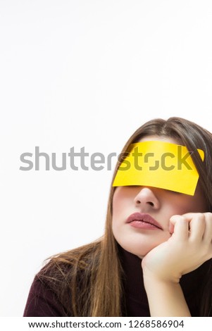 Closeup of Caucasian Woman in Burgundy Turtleneck Sweater With Yellow Sticky Note on Her Forehead. Against White Background.Vertical Image