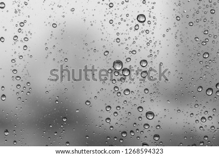 Water drops on glass window grey background after the rain in the autumn fall