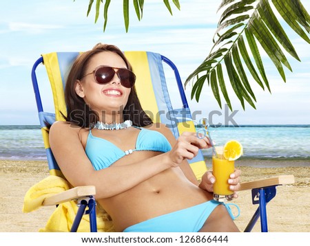 Girl in bikini drink juice through a straw. Outdoor.