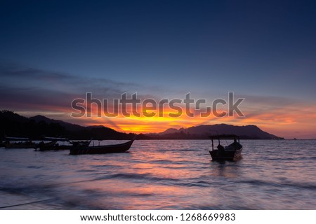 broken wood pier,boats on a beach during beautiful sunset