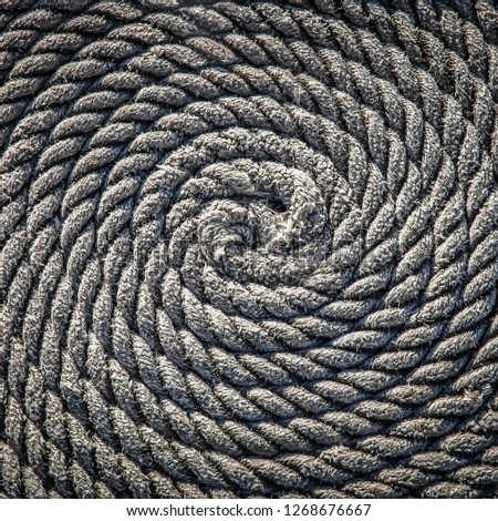 The rope for the boat laid in the form of a spiral. Background.