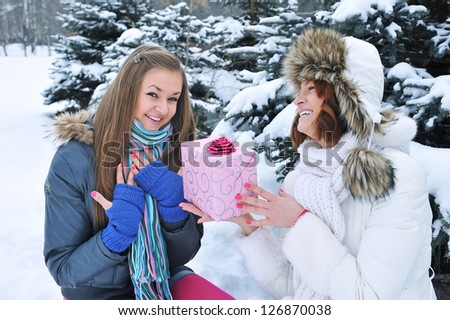 Young beautiful girls in winter with a gift