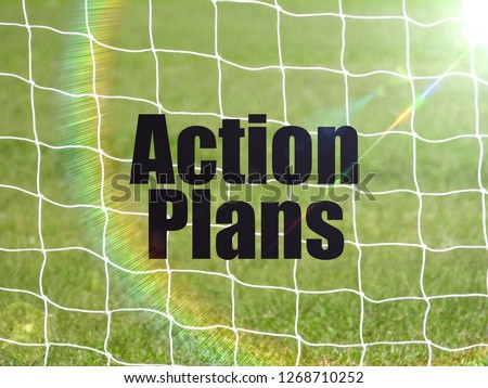 Soccer Goal Net and words ACTION PLANS on Green Grass Background with selective focus and crop fragment