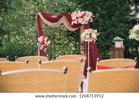 Beautiful wedding archway. Arch decorated with peachy and silvery cloth and flowers