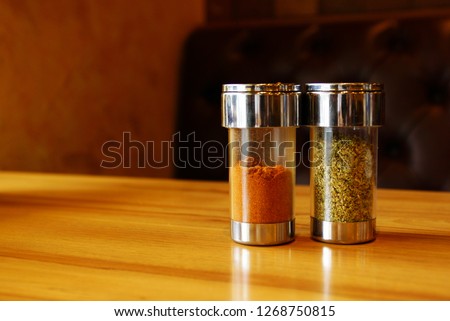 Oregano and Cayenne pepper on the wooden table.
