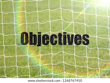 Soccer Goal Net and words OBJECTIVES on Green Grass Background with selective focus and crop fragment. Business and motivation concept