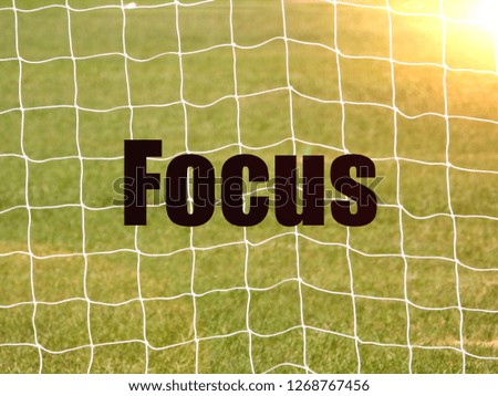 Soccer Goal Net and words FOCUS on Green Grass Background with selective focus and crop fragment. Business and motivation concept