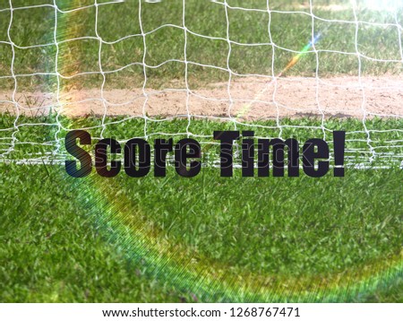 Soccer Goal Net and words SCORE TIME on Green Grass Background with selective focus and crop fragment. Business and motivation concept