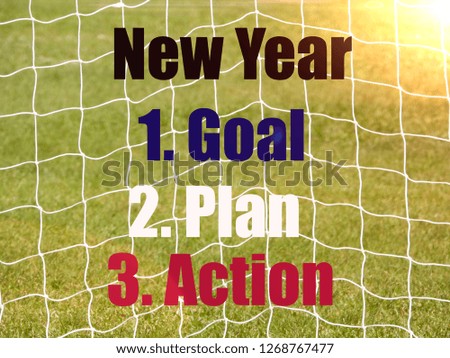 Soccer Goal Net and words NEW YEAR, GOAL, PLAN, ACTION on Green Grass Background with selective focus and crop fragment. Business and motivation concept