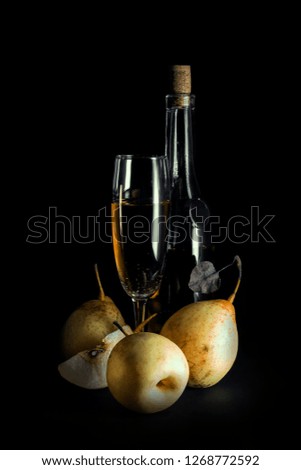 still life; bottle of wine, whole pears and half on a dark background