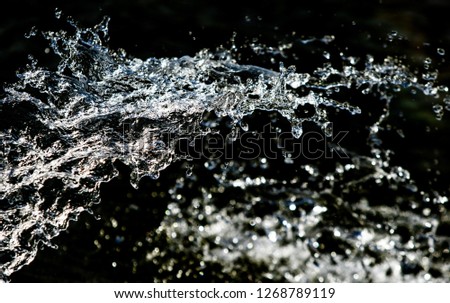 water drops in the air on a dark bokeh background