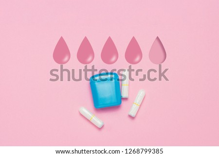 Feminine hygiene tampons and box for shipping and storage on a pink background. Concept of feminine hygiene during menstruation. Added drop mark, absorption level. Four drops. Flat lay, top view.