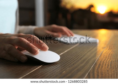 Woman using computer mouse and keyboard at table, closeup