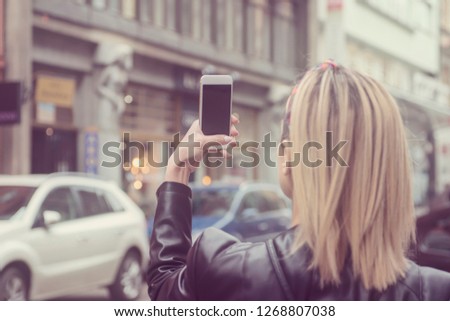 Young girl using smartphone in European city