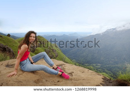 Young beautiful woman in the mountains, enjoying the view and beauty of nature.