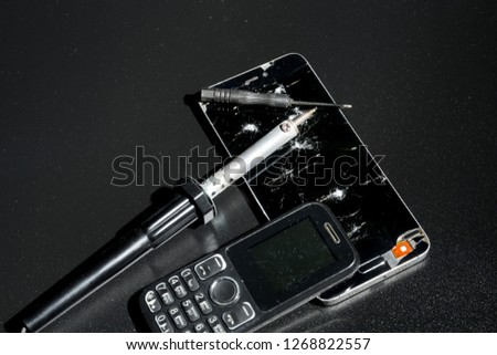 Repair phones with a broken screen on a dark background.