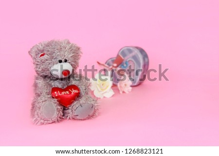 gray teddy bear with flowers on pink background for Valentine's Day