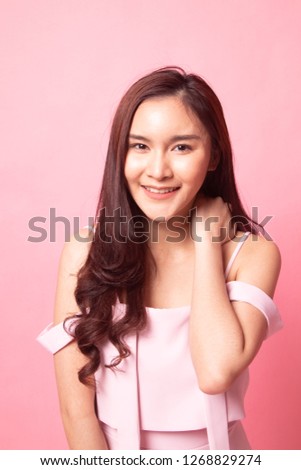 Portrait of beautiful young Asian woman on pink background