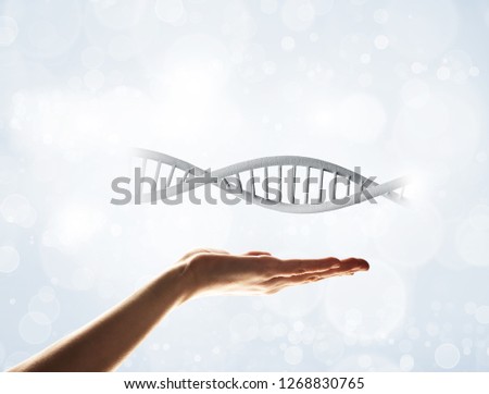 Close of human hand showing DNA molecule bokeh background