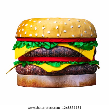 Big artificial burger isolated on white background. It is located in the street as advertising material. Close-up.