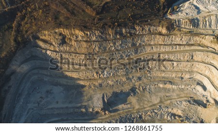 Panoramic view of quarry. Shot. Top view of picturesque quarry located on coastal mountain near village in forest. Concept of mining