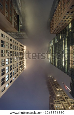 Low point of view of skyscrapers covered with fog from the upper deck of tourist bus 