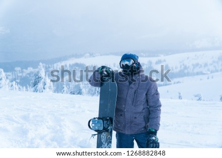 a man stands with snowboarding. stand mount. man snowboard