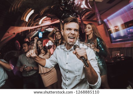 Sing in Karaoke. Men. Karaoke Club. Have Fun. Great Mood. Celebration. Dance Club. Holidays Concept. Dancing People. Young People. Sing.Microphone. Trendy Modern Nightclub. Party Maker. Birthday. Men.