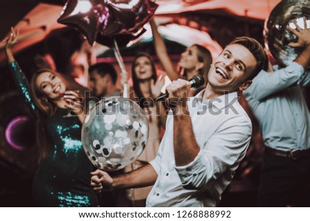 Balloons. Holidays Concept. Dancing People. Great Mood. Young People. Dance Club. Sing. Microphone. Trendy Modern Nightclub. Party Maker. Birthday. Karaoke Club. Celebration. Men. White Shirt.
